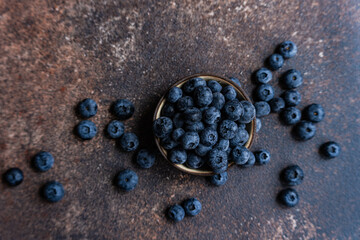 Fresh ripe blueberries in a bowl on rustic background