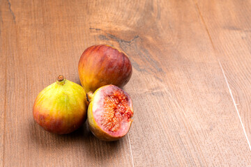 Freshly ripe figs. Healthy Mediterranean fig fruit. Fresh figs on a dark background. Beautiful blue violet figs with leaves, copy space, closeup