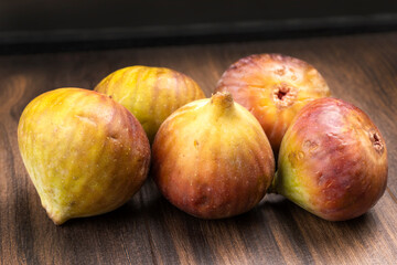 Freshly ripe figs. Healthy Mediterranean fig fruit. Fresh figs on a dark background. Beautiful blue violet figs with leaves, copy space, closeup