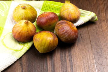 Freshly ripe figs. Healthy Mediterranean fig fruit. Fresh figs on a dark background. Beautiful blue violet figs with leaves, copy space, closeup