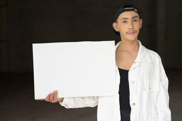young non binary gay man holding a blank sign