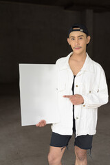 young non binary gay man holding a blank sign