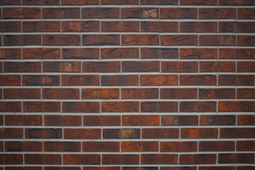 A full frame shot showcasing a reddish brown brick wall with light colored mortar lines in a seamless pattern