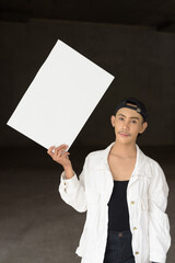 young non binary gay man holding a blank sign