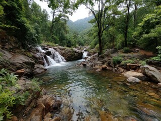 Serene Nature Scene with Flowing Waterfalls and Clear Green Waters Surrounded by Lush Forest and Rocky Terrain in a Tranquil Wilderness