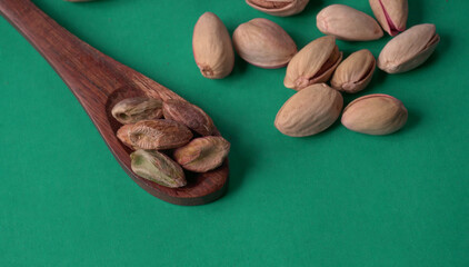 Pistachios or Pista nuts decorated with green leaves. plain background, top view.Flat lay.