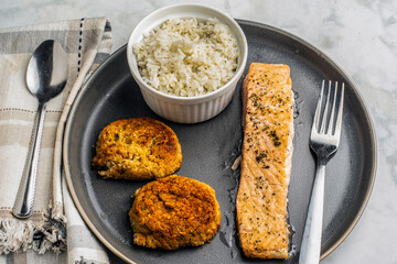 baked salmon served with crab cakes and rice