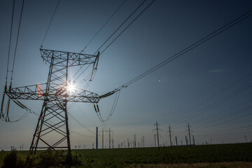High voltage power lines and pylons against blue sky. Electric tower. Power transmission lines....