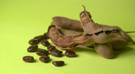 Tamarind fruit with seed isolated on green background with copy space for your text. Top view. Flat lay