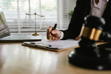 A professional lawyer sits at a desk surrounded by legal books, documents, and a gavel, providing...