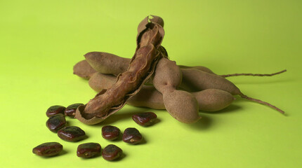 Tamarind fruit with seed isolated on green background with copy space for your text. Top view. Flat lay