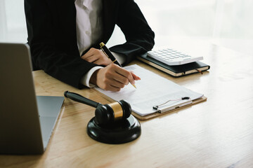 A professional lawyer sits at a desk surrounded by legal books, documents, and a gavel, providing...