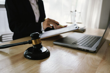 A professional lawyer sits at a desk surrounded by legal books, documents, and a gavel, providing...