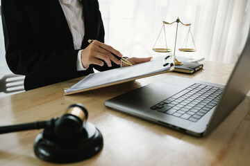 A professional lawyer sits at a desk surrounded by legal books, documents, and a gavel, providing...