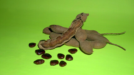 Tamarind fruit with seed isolated on green background with copy space for your text. Top view. Flat lay