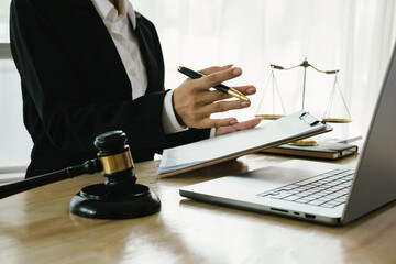 A professional lawyer sits at a desk surrounded by legal books, documents, and a gavel, providing...