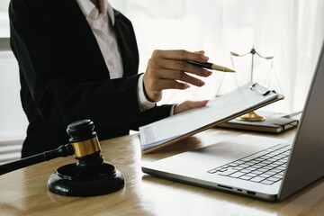 A professional lawyer sits at a desk surrounded by legal books, documents, and a gavel, providing...