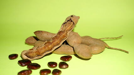 Tamarind fruit with seed isolated on green background with copy space for your text. Top view. Flat lay