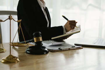 A professional lawyer sits at a desk surrounded by legal books, documents, and a gavel, providing...