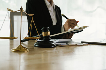 A professional lawyer sits at a desk surrounded by legal books, documents, and a gavel, providing...