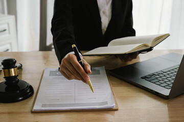 A professional lawyer sits at a desk surrounded by legal books, documents, and a gavel, providing...