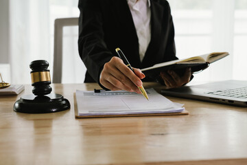 A professional lawyer sits at a desk surrounded by legal books, documents, and a gavel, providing...