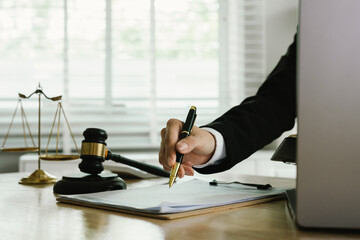 A professional lawyer sits at a desk surrounded by legal books, documents, and a gavel, providing...