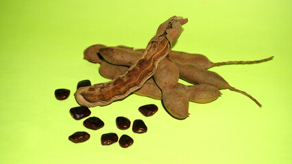 Tamarind fruit with seed isolated on green background with copy space for your text. Top view. Flat lay