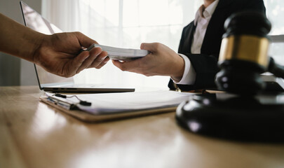 A hand holding stacks of money is shown being exchanged with another hand, implying a transaction,...