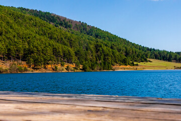 Scenic view of Lake Doxa from a wooden dock in Corinth, Greece, featuring bright blue water and...