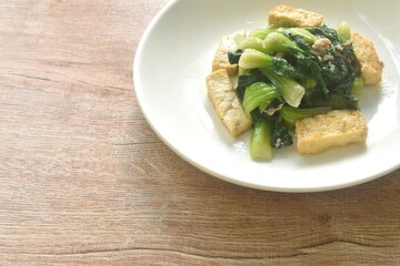 stir fried Chinese cabbage with slice tofu and chop pork in soy sauce on plate