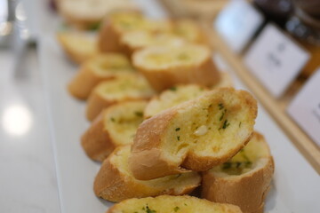 Three slices of garlic bread with fresh parsley on a white ceramic plate isolated on white. Top view. High quality photo
