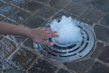 Children dip hands into water, Young tourists touch cool water surface, hands pressed against the...