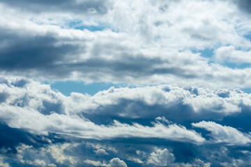 Bright and Dark Cloud Layers in Blue Sky Forming a Natural Atmospheric Texture with Light and Shadow Contrast.