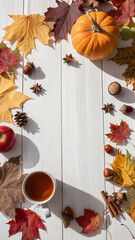 Warm tea, an open book, a cozy sweater, dry oak leaves, pine cones, and acorns create a relaxing autumn atmosphere on a white wooden background, perfect for a quiet afternoon