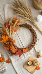 Crafting a beautiful autumn wreath on a table, adorned with dried flowers and vibrant fall leaves, surrounded by candles and pine cones, creates a warm, inviting atmosphere