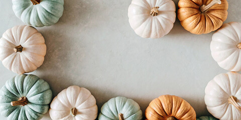 Stylish pastel colored and gold pumpkins forming a decorative frame on a light background, capturing the essence of autumn and halloween with a touch of elegance