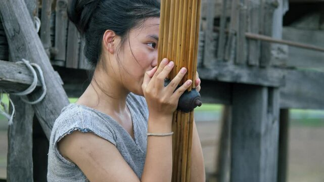 Young Asian woman playing the Khaen, a traditional musical instrument of the Isan region of Thailand. video 4K