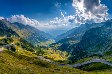 Scenic mountain valley with winding roads and lush green slopes under a dramatic sky