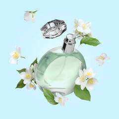Bottle of floral perfume and jasmine flowers in air on light blue background