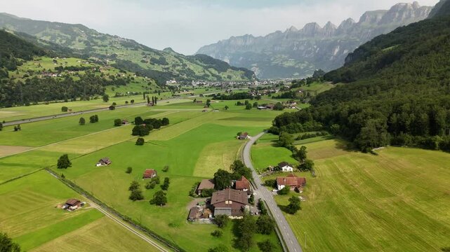 Scenic Aerial View of a Valley with Green Fields and Mountain Landscape in Switzerland near Flums, Berschis, and Walenstadt in the Canton of St. Gallen &ndash; Drone Footage
