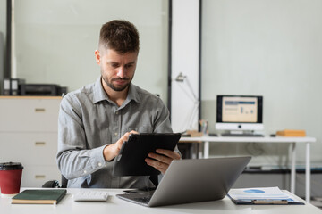 Businessman calculate and analyzing graph document financial with report and laptop in office.