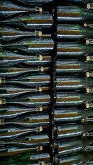 stacked green glass bottles arranged in an organized manner showcasing the collection and preparation for recycling or bottling processes, representing sustainability initiatives