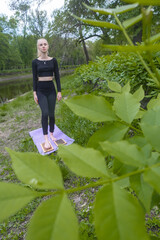 Young woman practicing yoga and meditating outdoors. Slim, flexible body. Concept of health, mindfulness, relaxation, vitality, and inner peace.