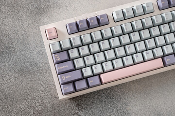 Modern mechanical keyboard on gray background. Minimal style and design keyboard. Custom build keyboard. Colorful key blue and white cap. Close up.