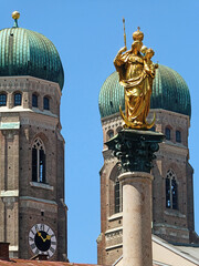 Munich Mary's column in Marienplatz with the golden statue of Virgin Mary and Child against the twin bell towers of the Frauenkirche (Cathedral of our Lady)