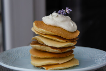 pancakes, pancakes, crepes close-up with sour cream and lavender flowers on a plate, delicious...