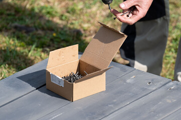 The craftsman uses a screwdriver to tighten the screws that secure the floor to the base of the...