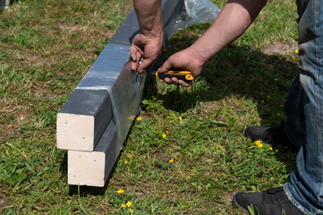 A person uses a stationery knife to cut the film on the boards.
