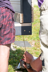 A master carpenter is driving large screws to secure the frame and floor in the gazebo.